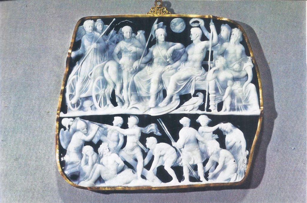 The Gemma Augustea, or Vienna cAmeo, showing Augustus seated with the Goddess Roma; to one side, the victorious Tiberius steps from his chariot. In the lower register, captive Germans are held by the hair, while Roman soldiers erect a trophy of victory.