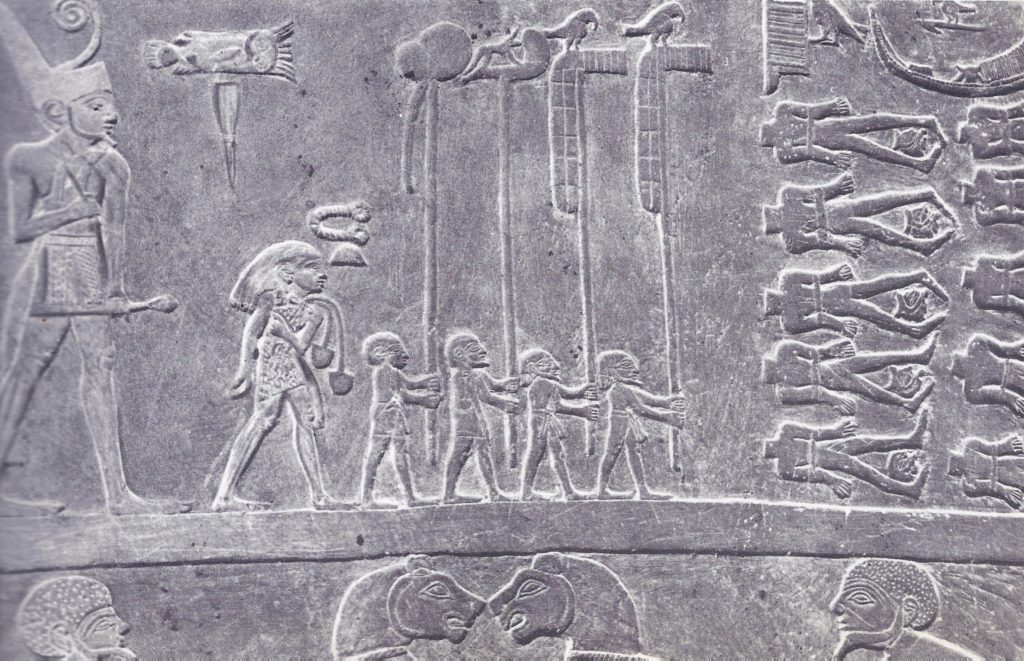 3000 BC Detail from the reverse side of the Palette of Narmer. The Pharaoh is walking in procession, wearing the red crown of Lower Egypt, preceded by his standard-bearers. Before them are the rows of decapitated enemies.